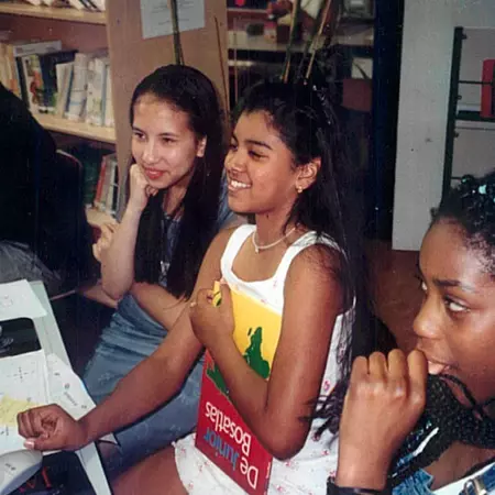 Children work in groups, sharing the computer